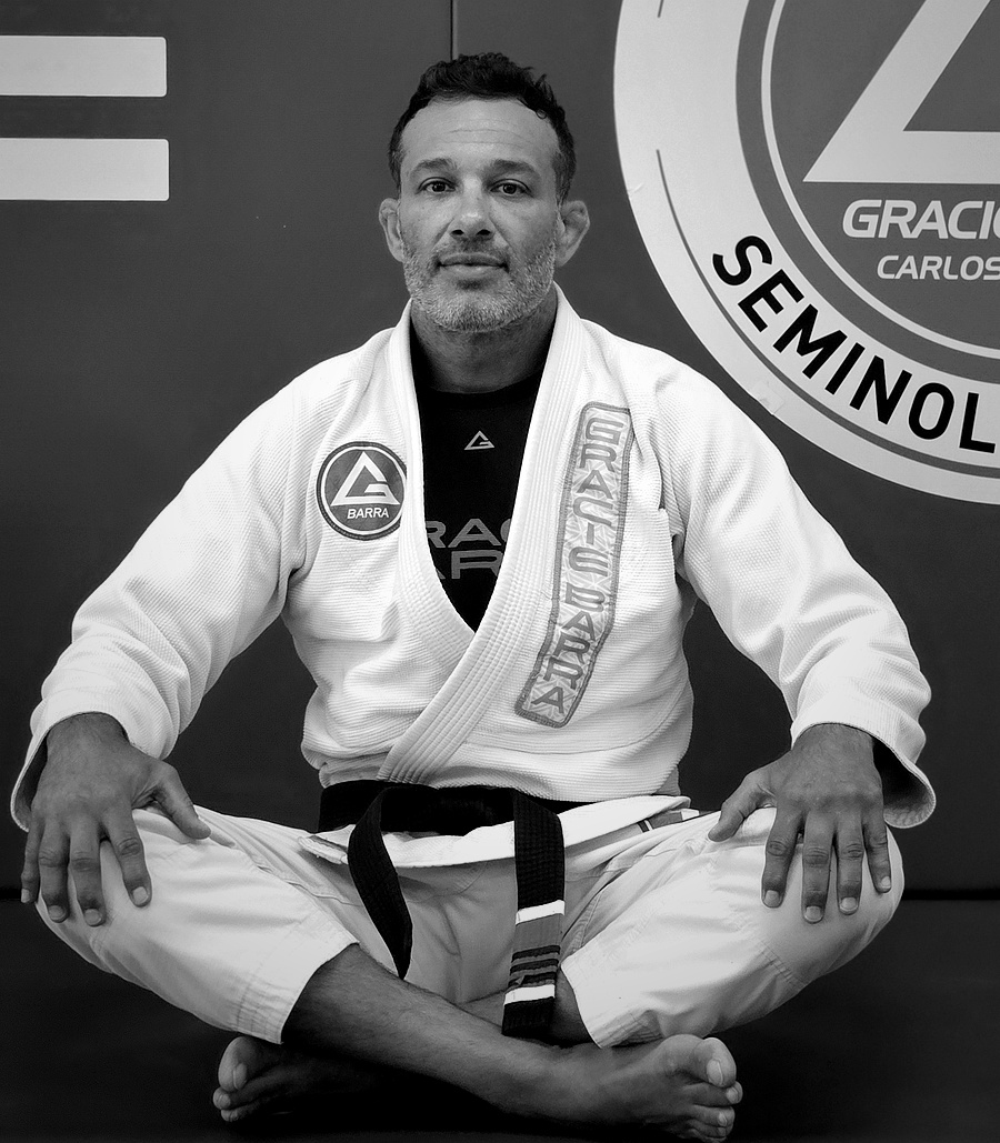 Professor Rodrigo Costa, Head Professor of Gracie Barra Seminole, seated full-figure in his 4th degree black belt gi